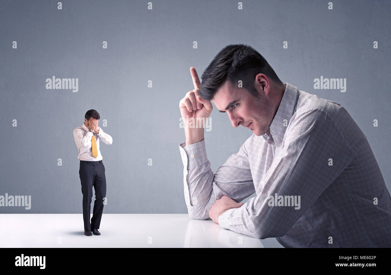 Giovane imprenditore professionale essendo arrabbiato con un altro imprenditore in miniatura Foto Stock