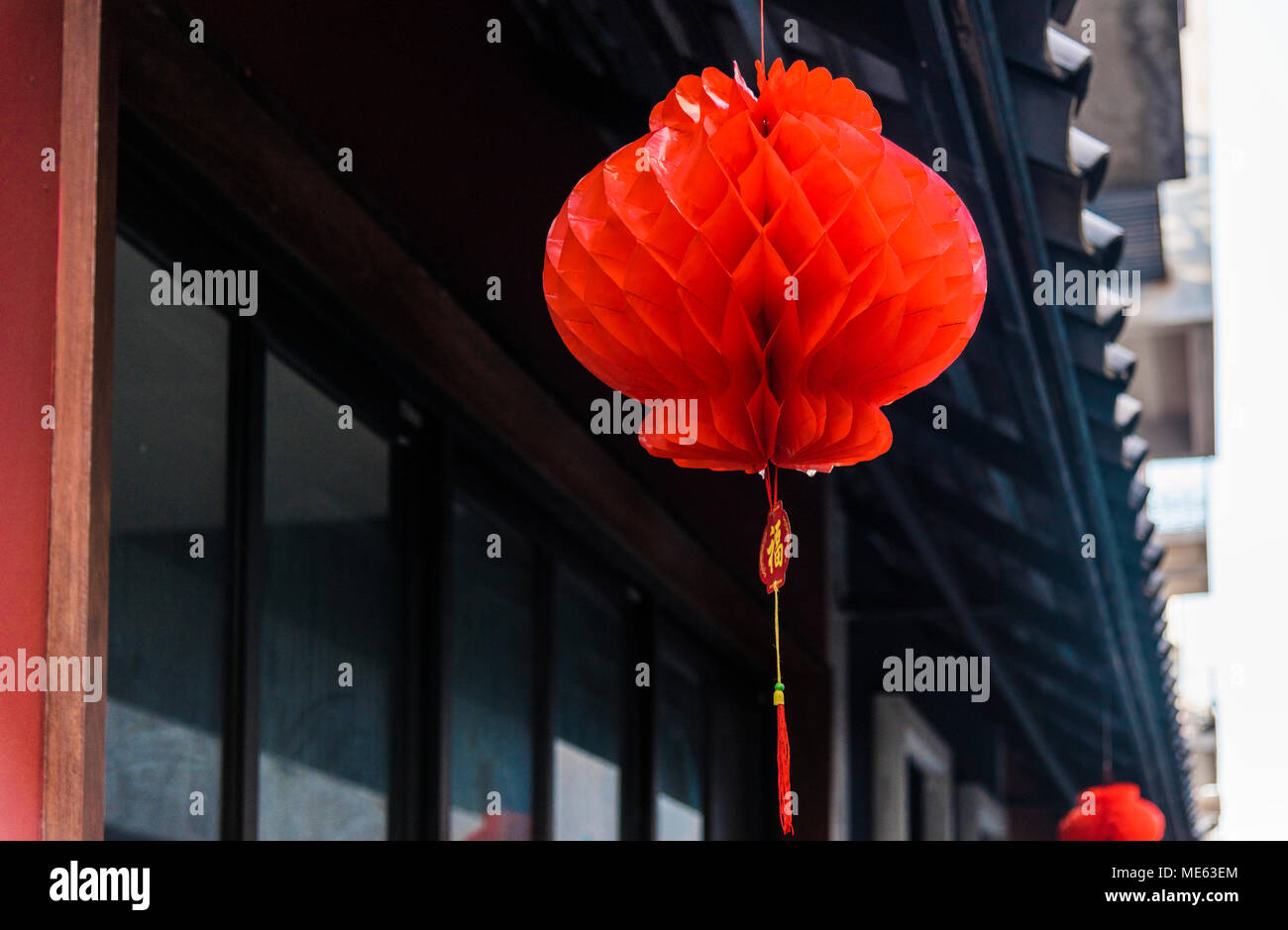 Primo piano della rossa di carta a nido d'ape lanterna Foto Stock