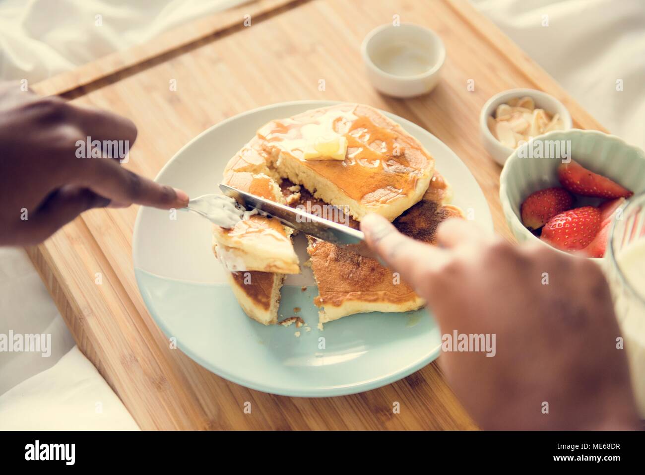 Una persona avente la colazione a letto Foto Stock