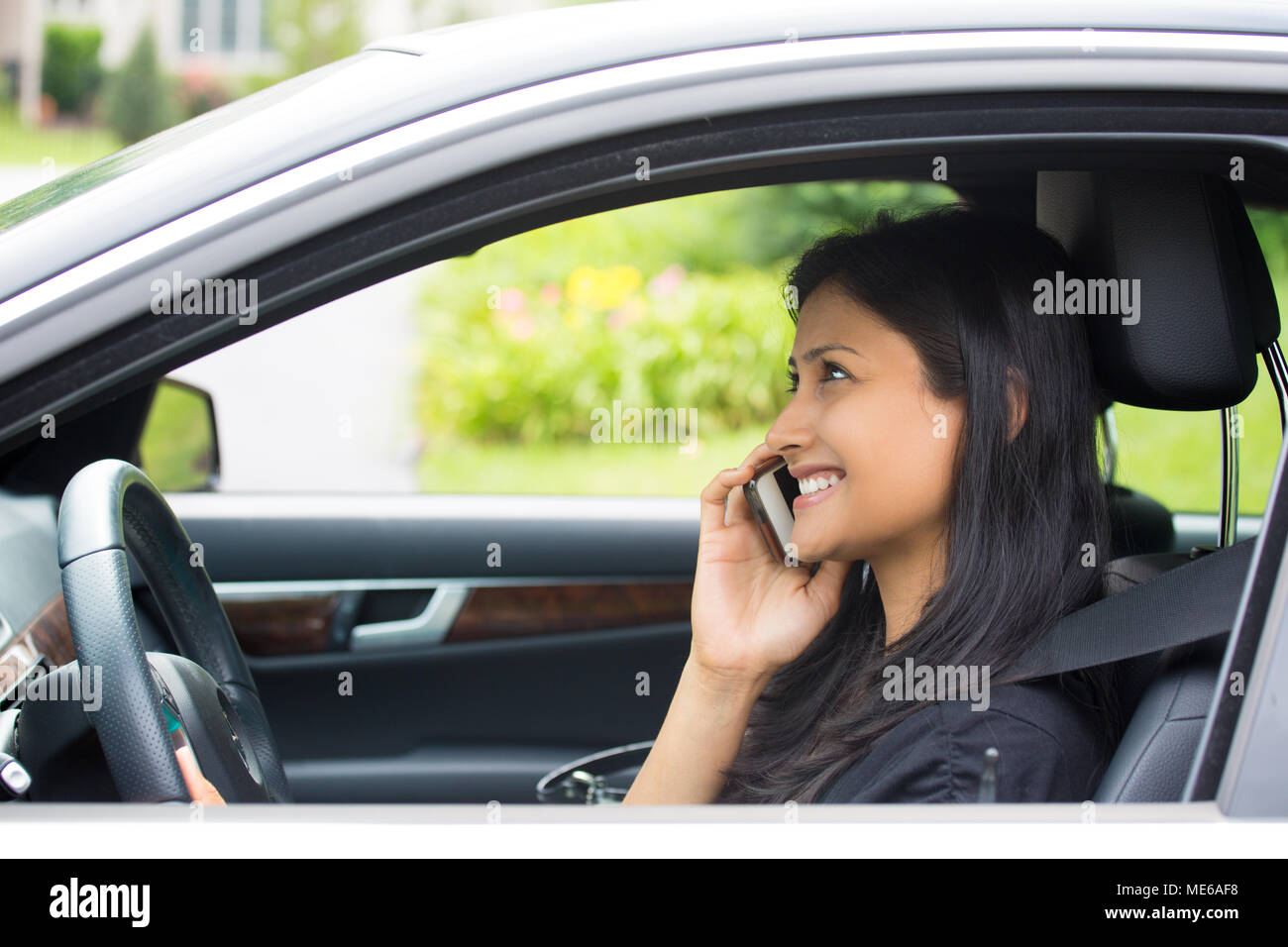Closeup Ritratto, giovane donna con buone notizie, felicemente parlando al cellulare mentre si guida, isolato al di fuori dello sfondo. Foto Stock