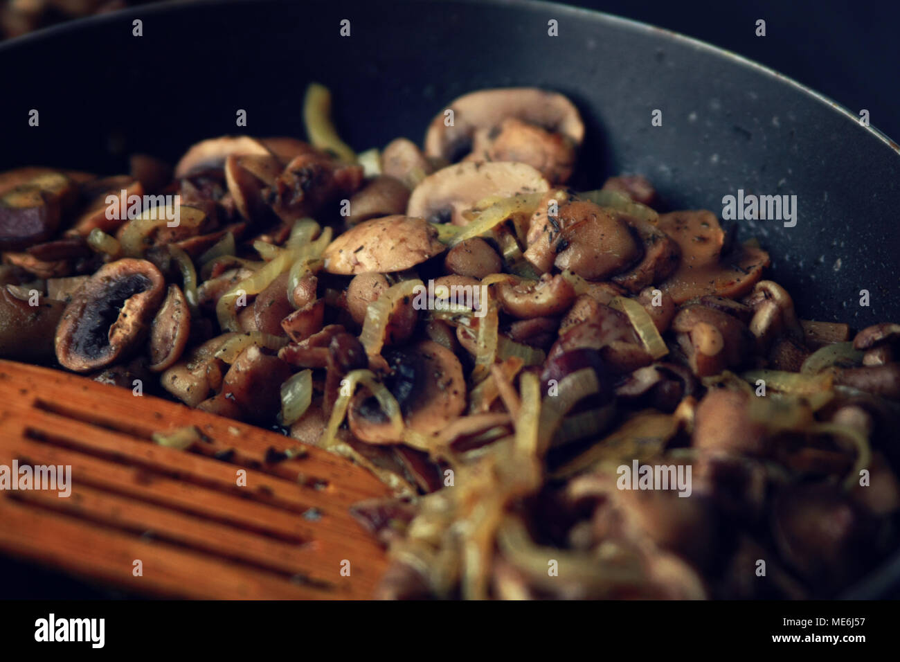 Una padella con un fritto di funghi. Piatto vegano. Funghi Fritti e la cipolla nella padella. Cucina Europea. Panoramica di funghi fritti. Semplice mi vegetariano Foto Stock
