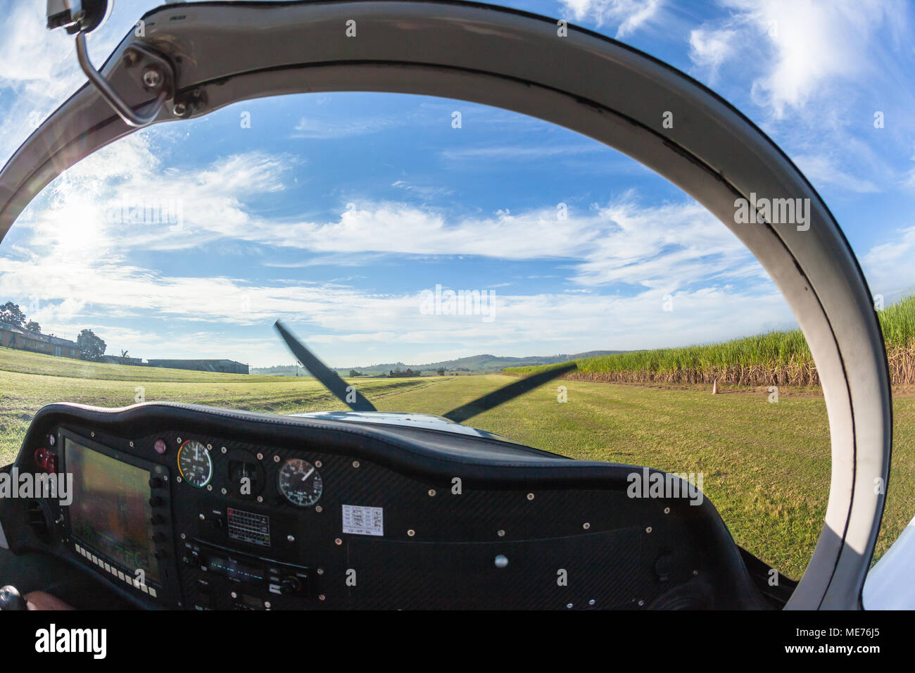 Piccolo singolo prop motore degli aerei pilota piano interno abitacolo visualizza togliere la fattoria rurale pista in erba airfield. Foto Stock