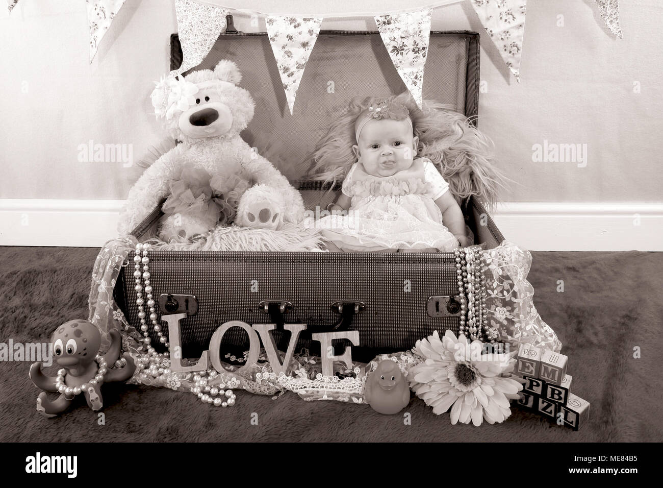 3 mese fa bambina esplorando in vivaio, lo sviluppo cognitivo, in una valigia vintage Foto Stock