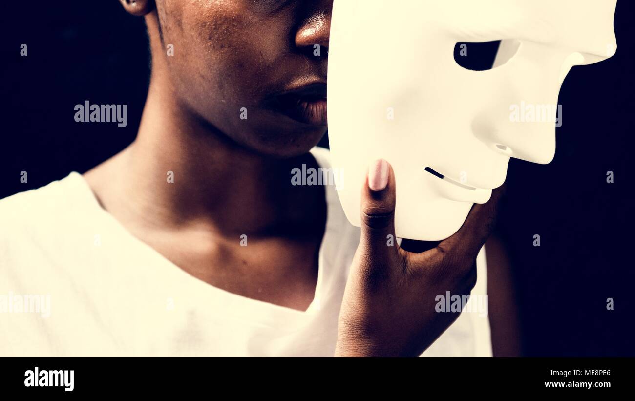 Donna africana holding maschera bianca Foto Stock