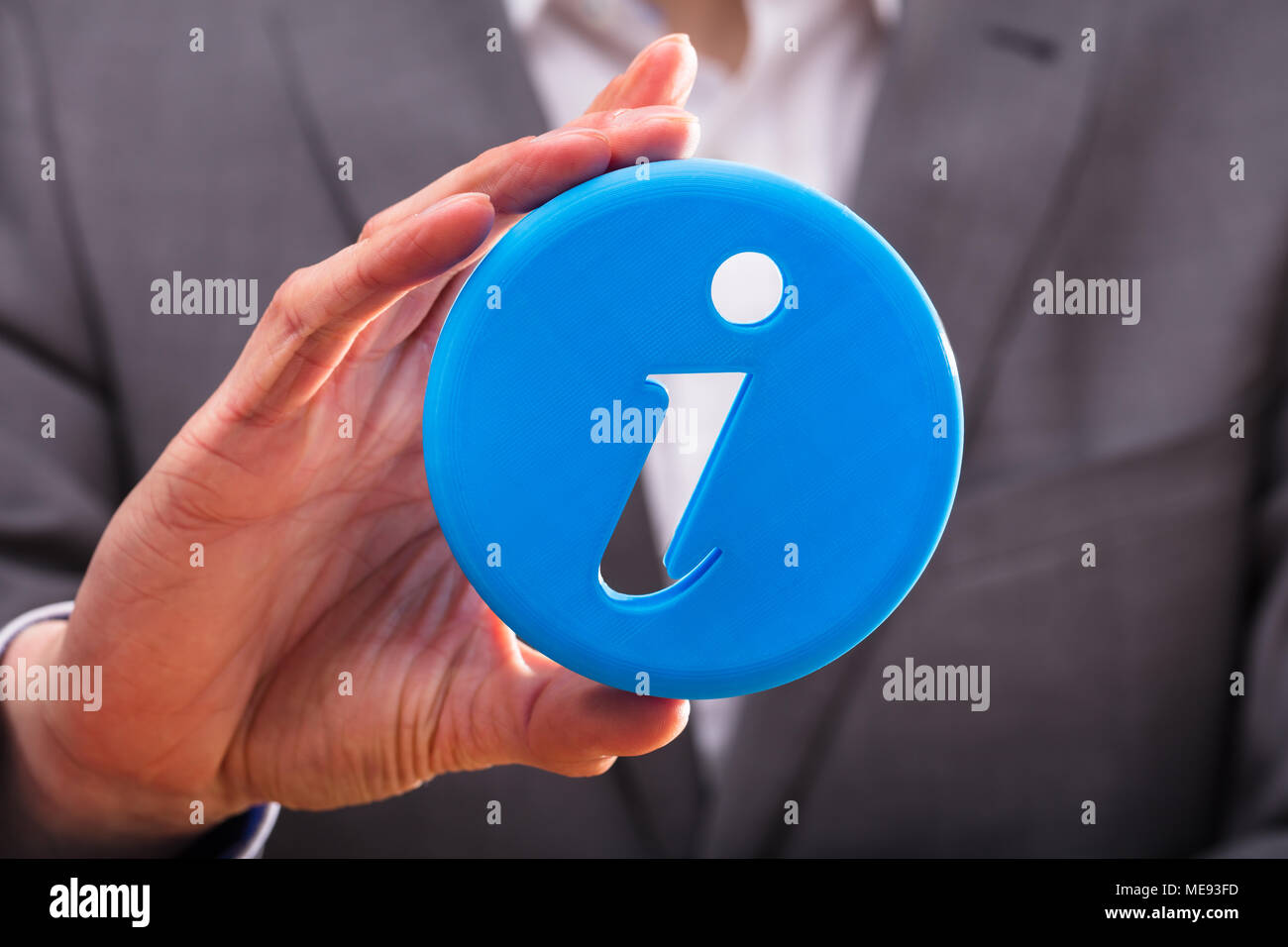 Close-up di un imprenditore la mano che regge il blu icona delle informazioni Foto Stock