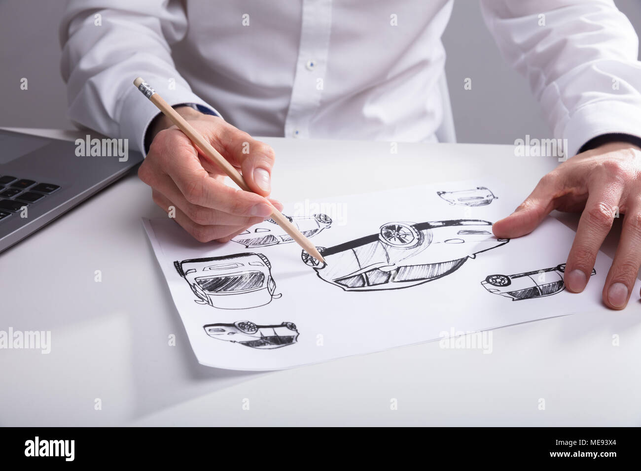 Close-up di un artista schizzi a mano su un foglio di carta con la penna sulla scrivania Foto Stock