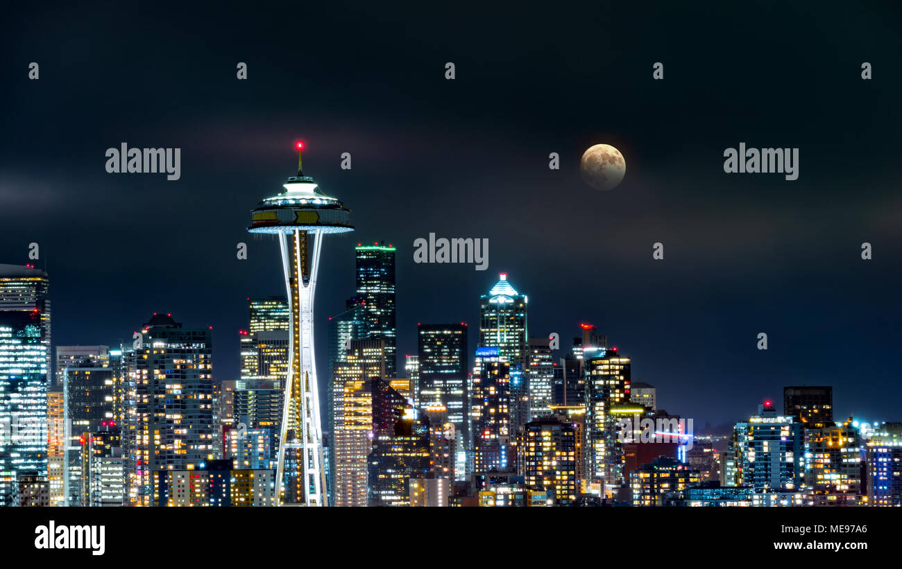 La luna piena sorge sopra lo skyline di Seattle, come visto da notte da Kerry Park. Foto Stock
