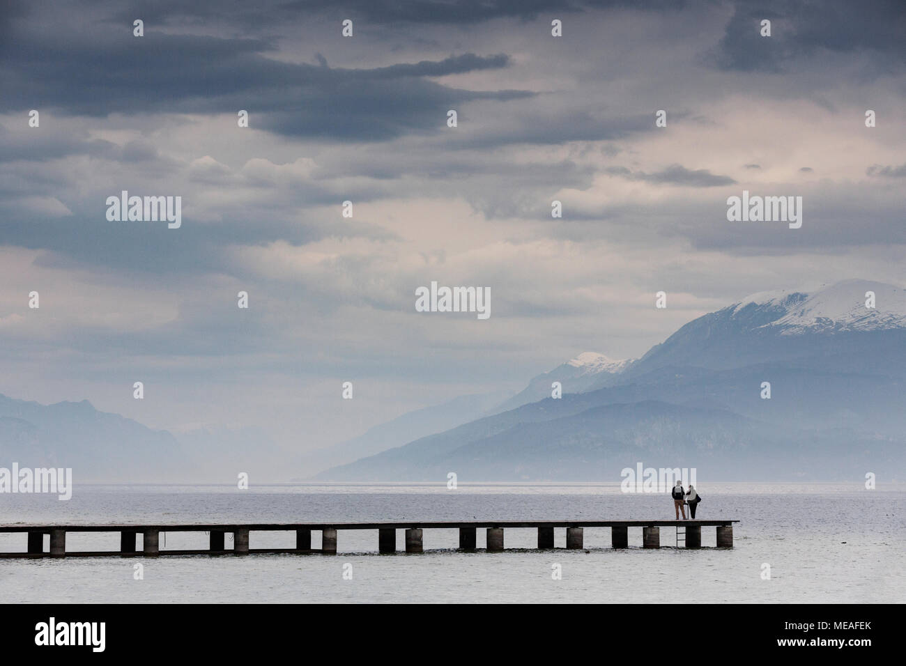 Un paio di prendere in vista da un molo passerella a Sirmione, sul lato sud del Lago di Garda, Italia. Foto Stock