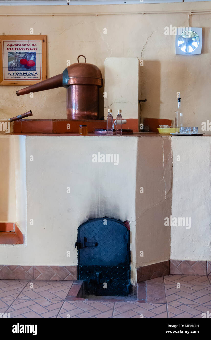 Rame pentola di distillazione con woodburning firepit a Medronho portoghese  "Firewater distilleria Foto stock - Alamy