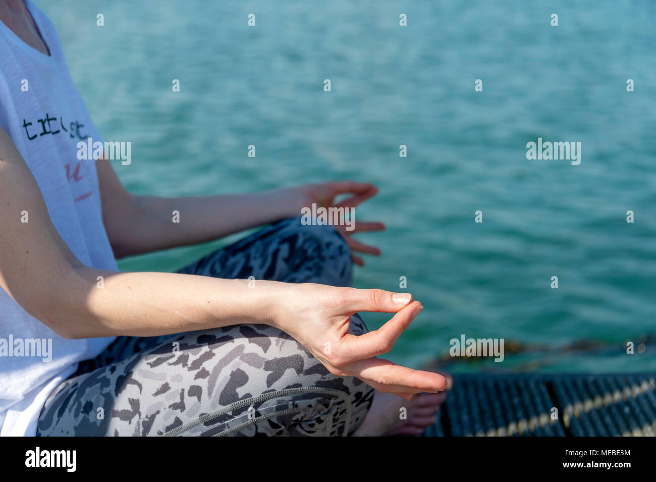 In prossimità di una donna a praticare yoga accanto all acqua, meditazione e relax. Foto Stock