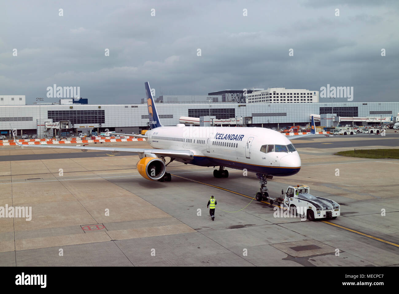 Dall'Aeroporto Gatwick di Londra, Surrey, Regno Unito 2018. Rimorchiatore spinge un Icelandair Boeing 757-200 jet del passeggero per la pista di rullaggio Foto Stock