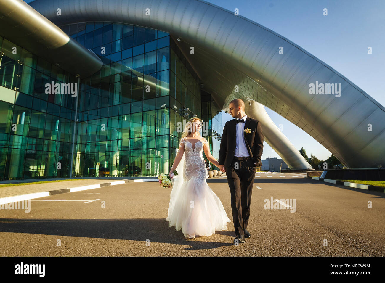 Sposa e lo sposo a piedi vicino all'edificio futuristico Foto Stock