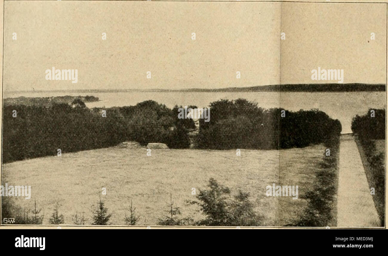 . Die Gartenwelt . Blick vom Park nach der Flensburger Föhrde und Südhaff, gelegen; umfaßt Sie einen Flächeninhalt von 33 Hektar. Die ganze Umgebung ist wegen des hügeligen, meist bewaldeten Terrains als geradezu malerisch zu bezeichnen. Südhaffer Dem Ufer sind zwei größere isole vorgelagert, welche mit ihren Wäldern und grünen Wiesen das reizvolle Panorama noch verschönern. Der Besitzung gegenüber, am jenseitigen bewaldeten Ufer der Föhrde, liegt der bekannte Badeort Glücksburg, während sich im Südwesten die staatliche neue Marineschule erhebt. Läßt man den Blick weiter nach Westen schweifen Foto Stock