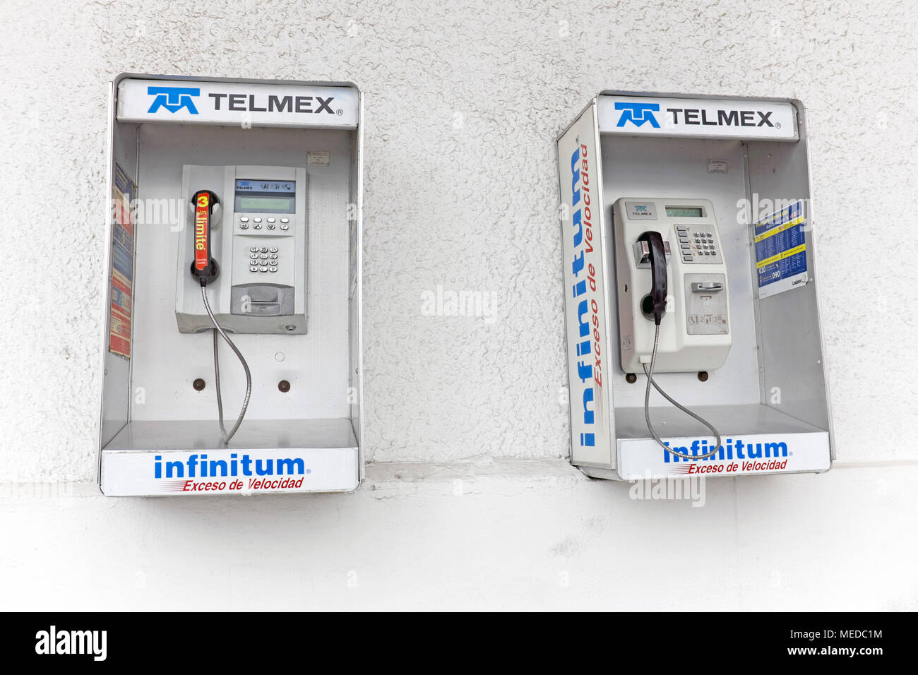 Due telefoni pubblici sono fissati ad una parete in stucco a Città del Messico. Foto Stock