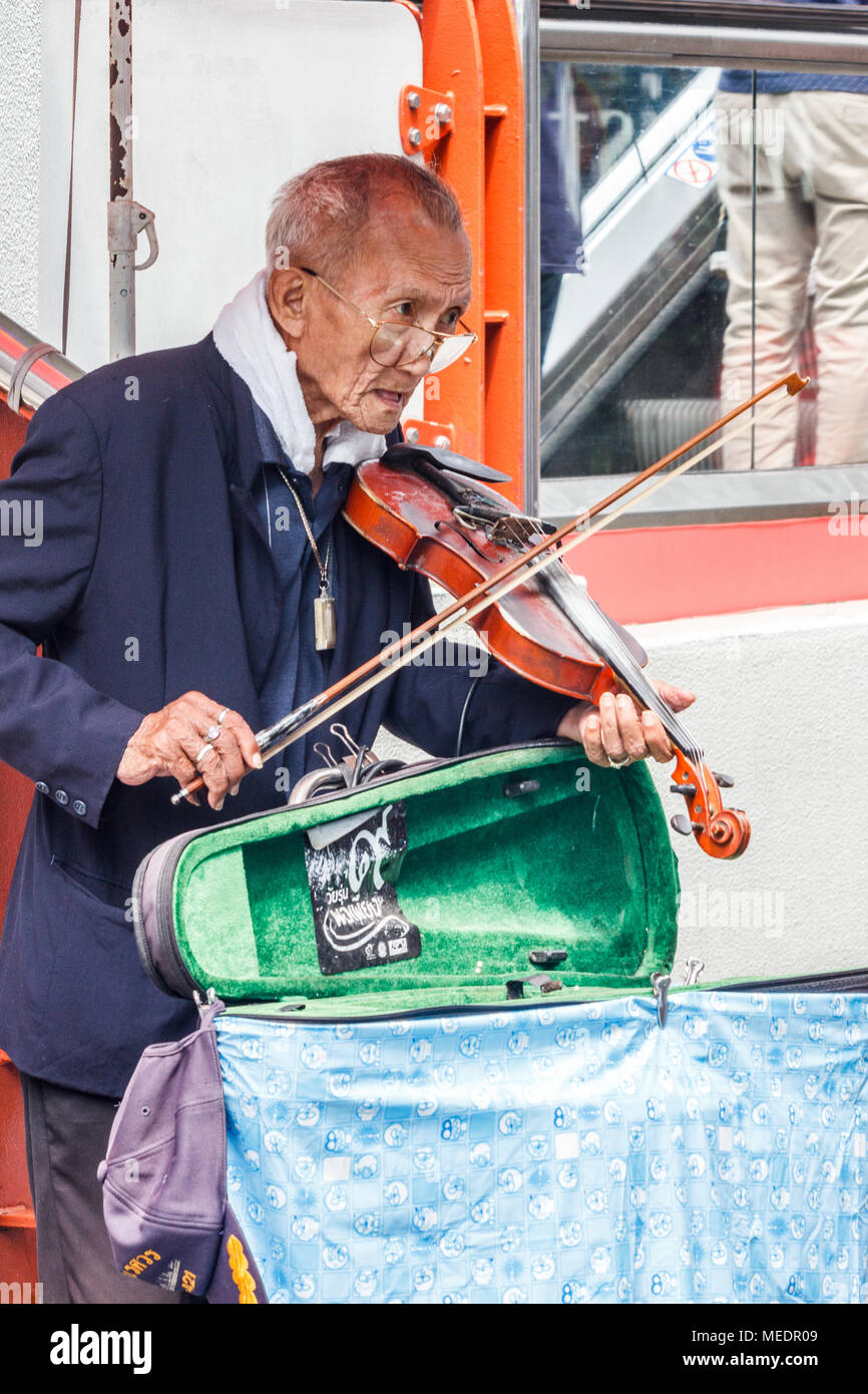 Il vecchio uomo con violino musicista di strada per denaro, Bangkok, Thailandia Foto Stock