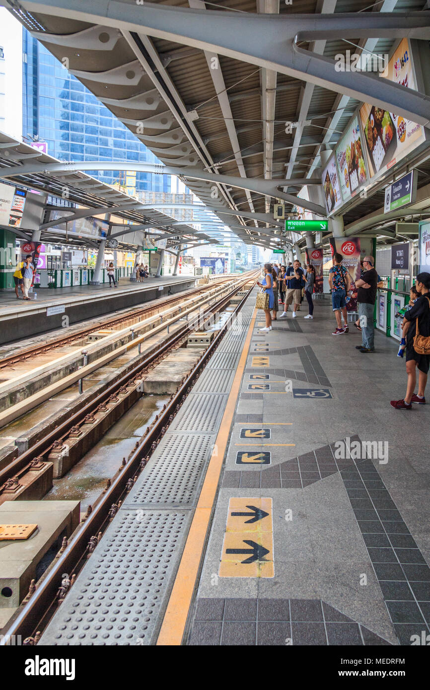 Persone in attesa sulla piattaforma per lo Skytrain, la stazione di Nana, Bangkok, Thailandia Foto Stock