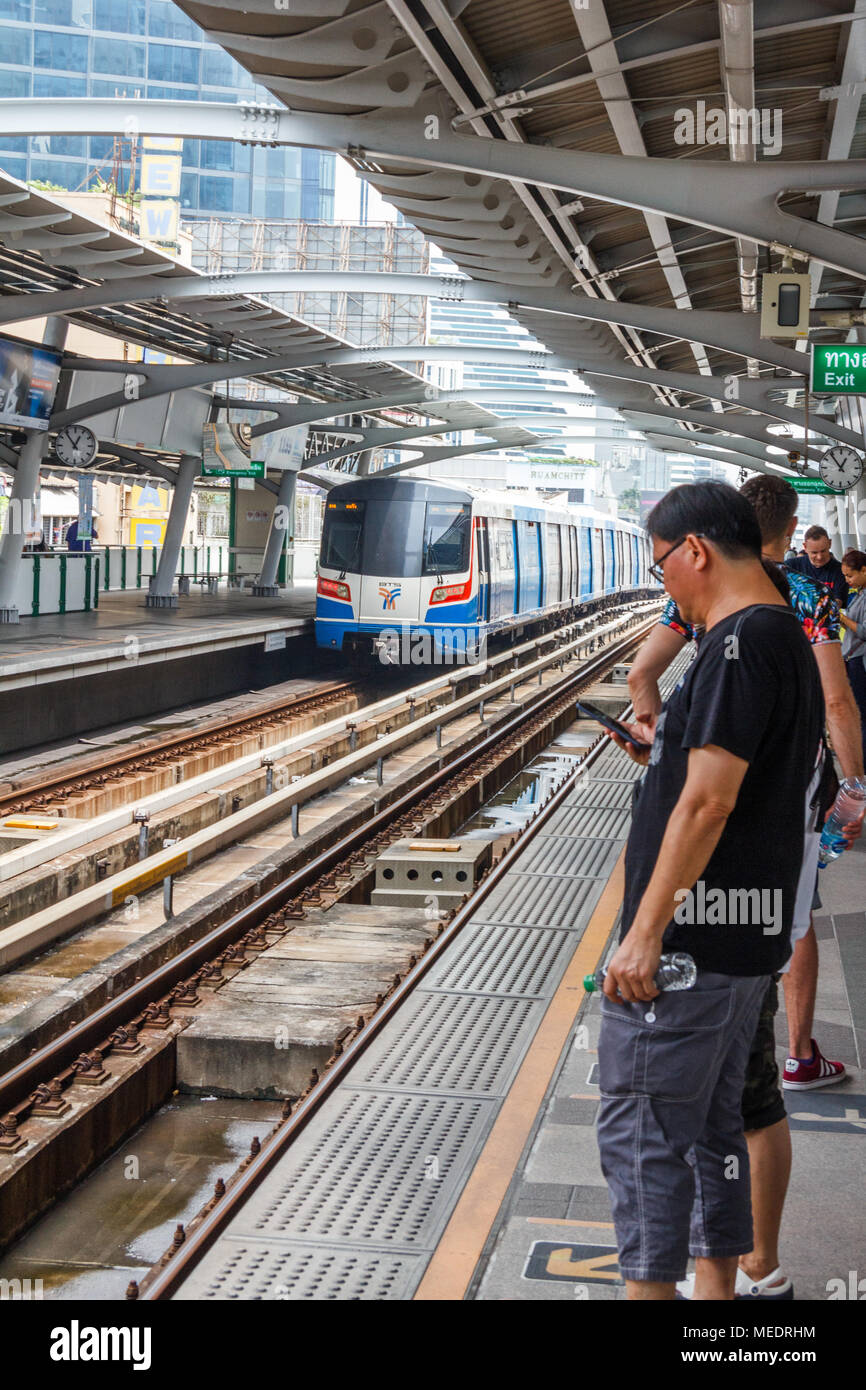 Persone in attesa sulla piattaforma per lo Skytrain, la stazione di Nana, Bangkok, Thailandia Foto Stock