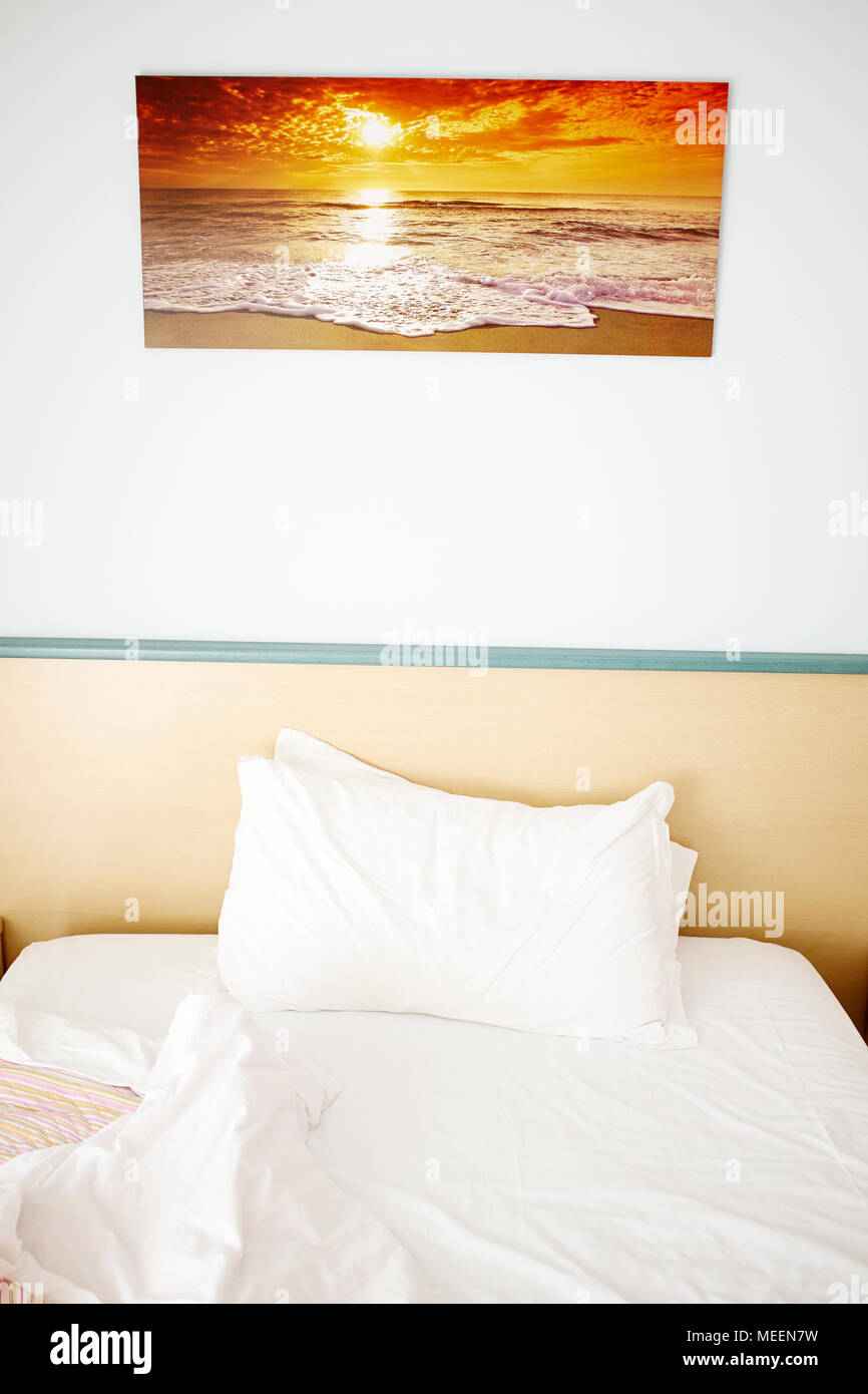 Buon Giorno ! - Un unico disfatto hotel camera letto con un tramonto fotografia sulla parete sopra Foto Stock