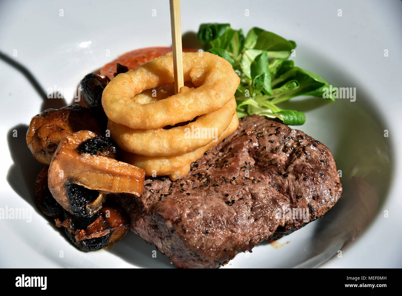 Le immagini mostrano il cibo placcato, formaggio hamburger con anelli di cipolla pomodoro e lattuga, una bistecca e pasto a fungo e una pancetta e piatto di pollo. Foto Stock