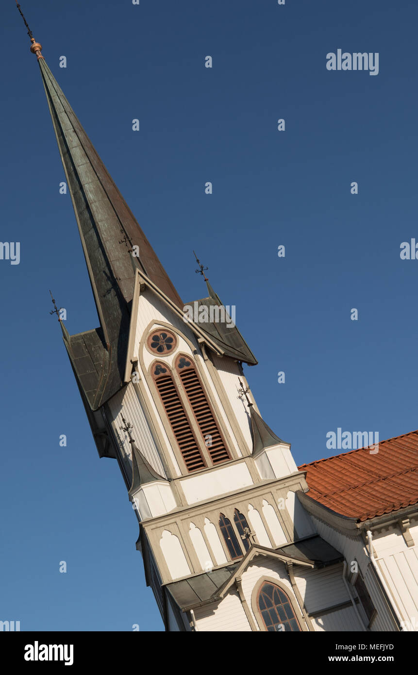 Immagine inclinata della torre di Bamble chiesa, una grande chiesa in legno. Inverno, la neve e il sole e cielo blu. L'immagine verticale. Foto Stock
