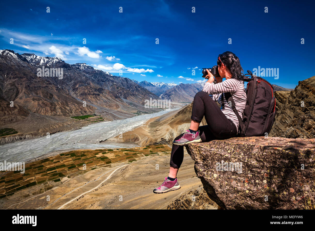 Dhankar gompa. Spiti Valley, Himachal Pradesh, India. Fotografo di natura turistico con fotocamera germogli mentre permanente sulla cima della montagna. Foto Stock