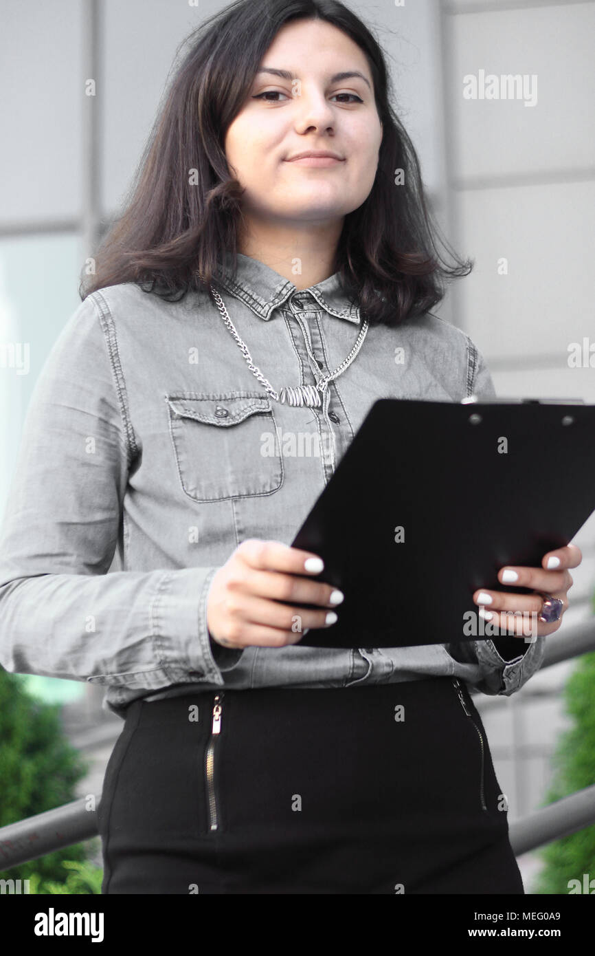 Dipendente con una clipboard stando sul balcone dell'ufficio Foto Stock