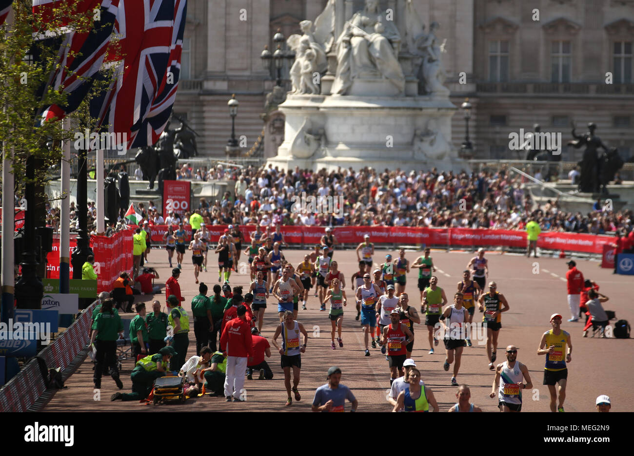 Un runner riceve un trattamento medico dopo il collasso di metri dal traguardo durante il 2018 denaro Virgin London Marathon. Foto Stock