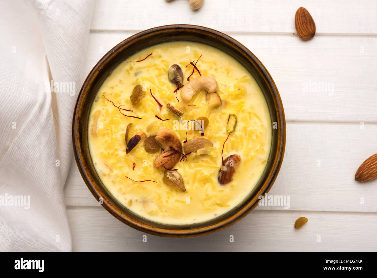 Kheer o budino di riso è un dessert indiani in un marrone recipiente di terracotta con frutta secca condimenti Foto Stock