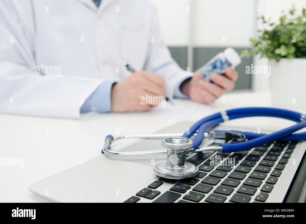 Medico che lavorano in ospedale. Lo stetoscopio sulla tastiera del notebook. Medico sanitario in consultazione policlinico ospedale o concetto Foto Stock