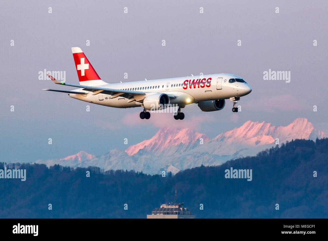 Aereo nell approccio su Zurigo ZRH, coperta di neve delle Alpi. HB-JCD, Svizzero, Bombardier BD-500. Foto Stock