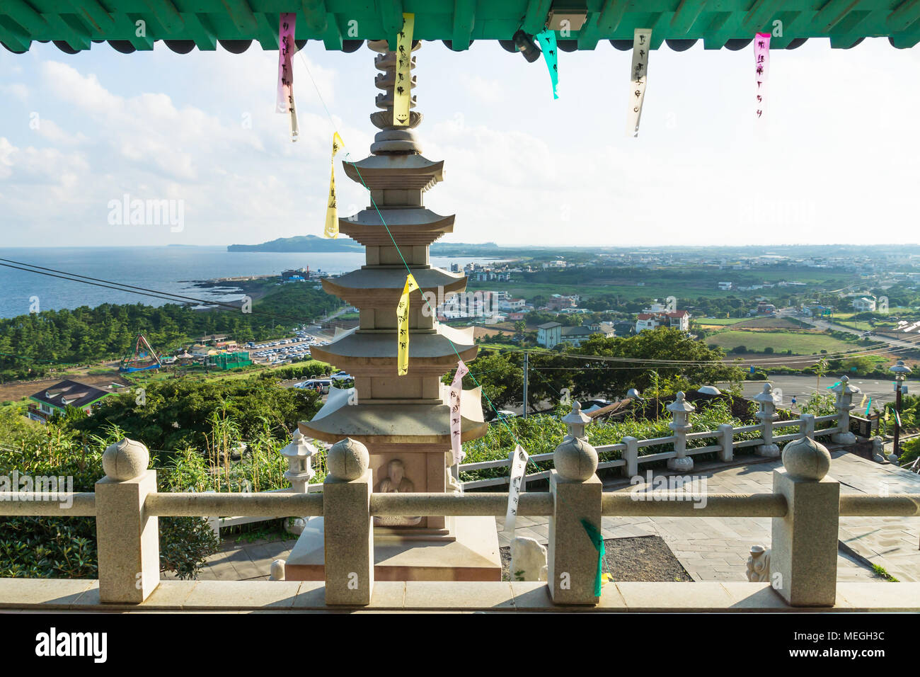 Vista sulla costa al tempio Sanbanggulsa con Stupa e preghiera nastri, Sanbang-ro, Jeju Island, Corea del Sud Foto Stock