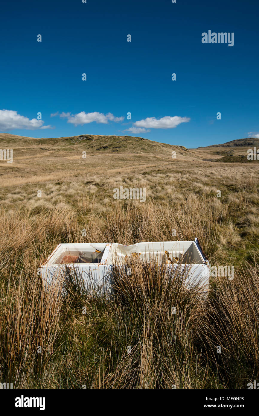 Volare a punta di un frigorifero con congelatore oggetto di pratiche di dumping su una brughiera nel Galles del Nord. Il frigorifero con congelatore oggetto di pratiche di dumping su y Migneint, un altopiano di Moro e di torbiera e SSSI Foto Stock