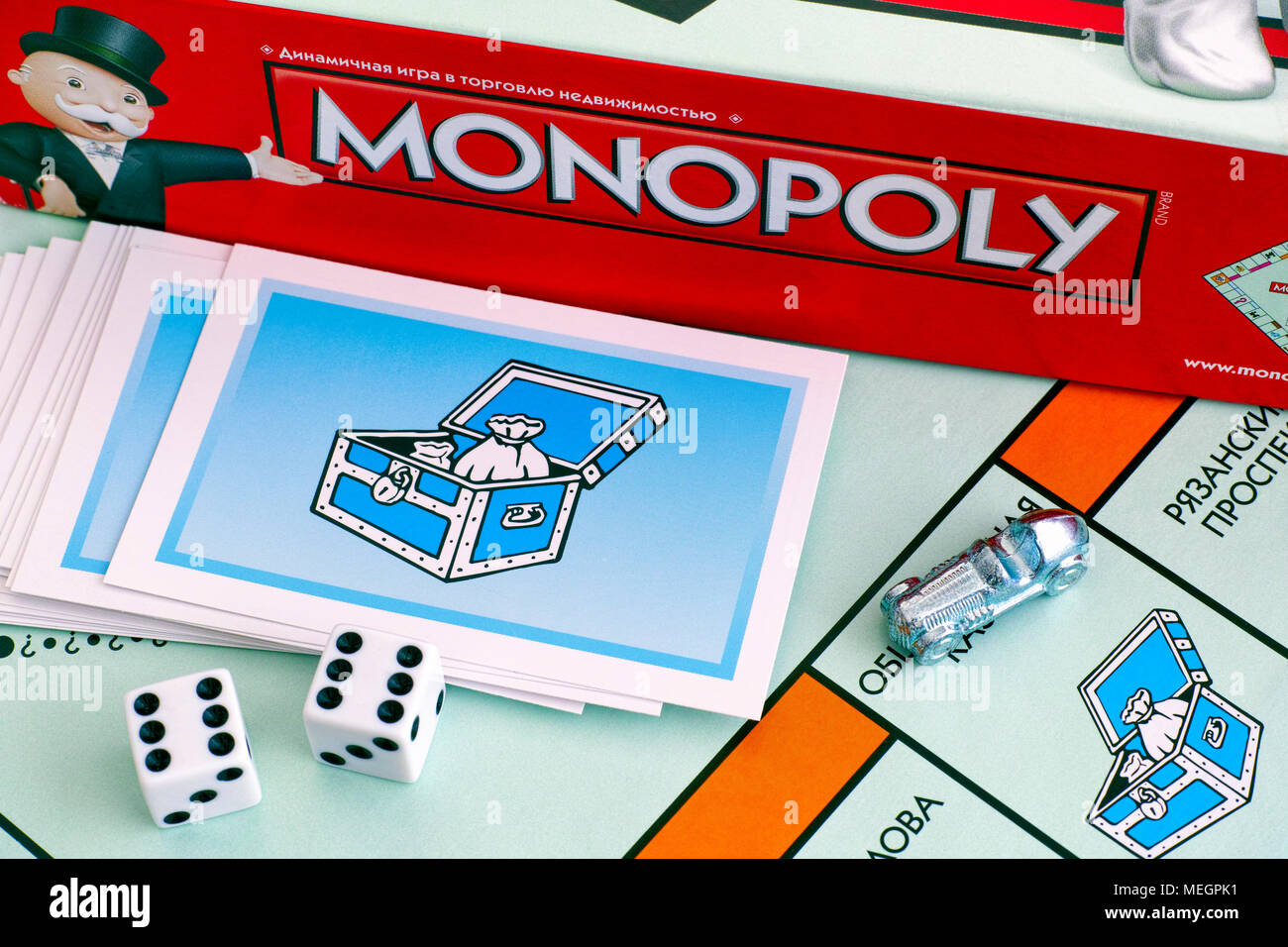 Tambov, Federazione Russa - 26 gennaio 2018 monopolio Board Game Box, Community Chest card, token, cubetti su gameboard. Studio shot. Foto Stock