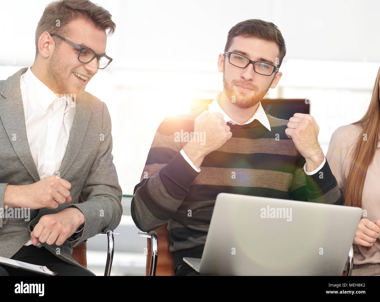 Tre dipendenti eccitati ricevendo buone notizie insieme sulla linea Foto Stock