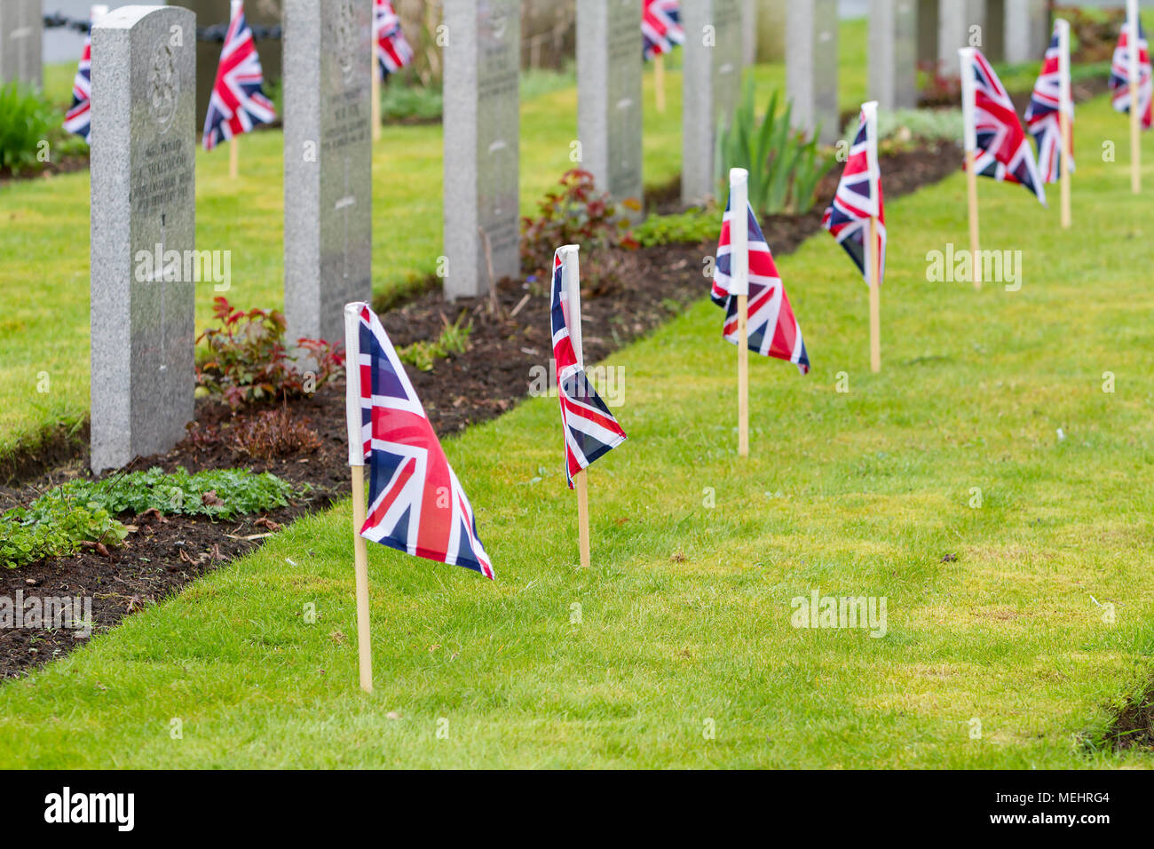 Righe di tombe per i caduti morti con unione bandiere nel soldato' Angolo del cimitero di Warrington per l anniversario di Anzac Day - Warrington, Regno Unito, 22 aprile 2018. L'Anniversario di Anzac Day è stato commemorato domenica 22 aprile 2018 soldati nell' angolo del cimitero di Warrington quando il vice sindaco, Cllr Karen Mundry, Cadetti dalla regina del reggimento Lancashire, Warrington Cadetti del mare e molti veterani sono state presenze in credito: John Hopkins/Alamy Live News Foto Stock