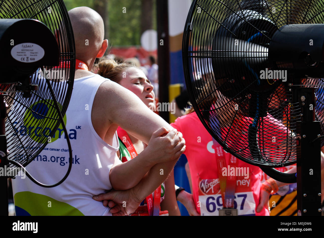 Londra, Regno Unito. Il 22 aprile 2018. Corridori della maratona si raffreddi accanto al grande fan al traguardo in una delle più calde registrate i giorni di gara con temperature che raggiungono un elevato di 24 gradi Celsius durante la domenica la Vergine denaro maratona di Londra.. Credito: Elsie Kibue / Alamy Live News Foto Stock