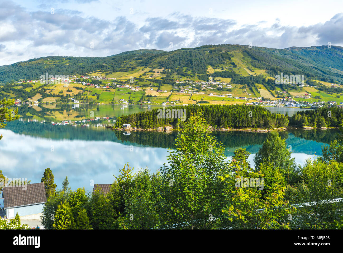 Lago Hafslovatnet, Hafslo, Norvegia, mirroring del paesaggio colorato, villaggi e prati nel lago vicino il Lustrafjorden Foto Stock