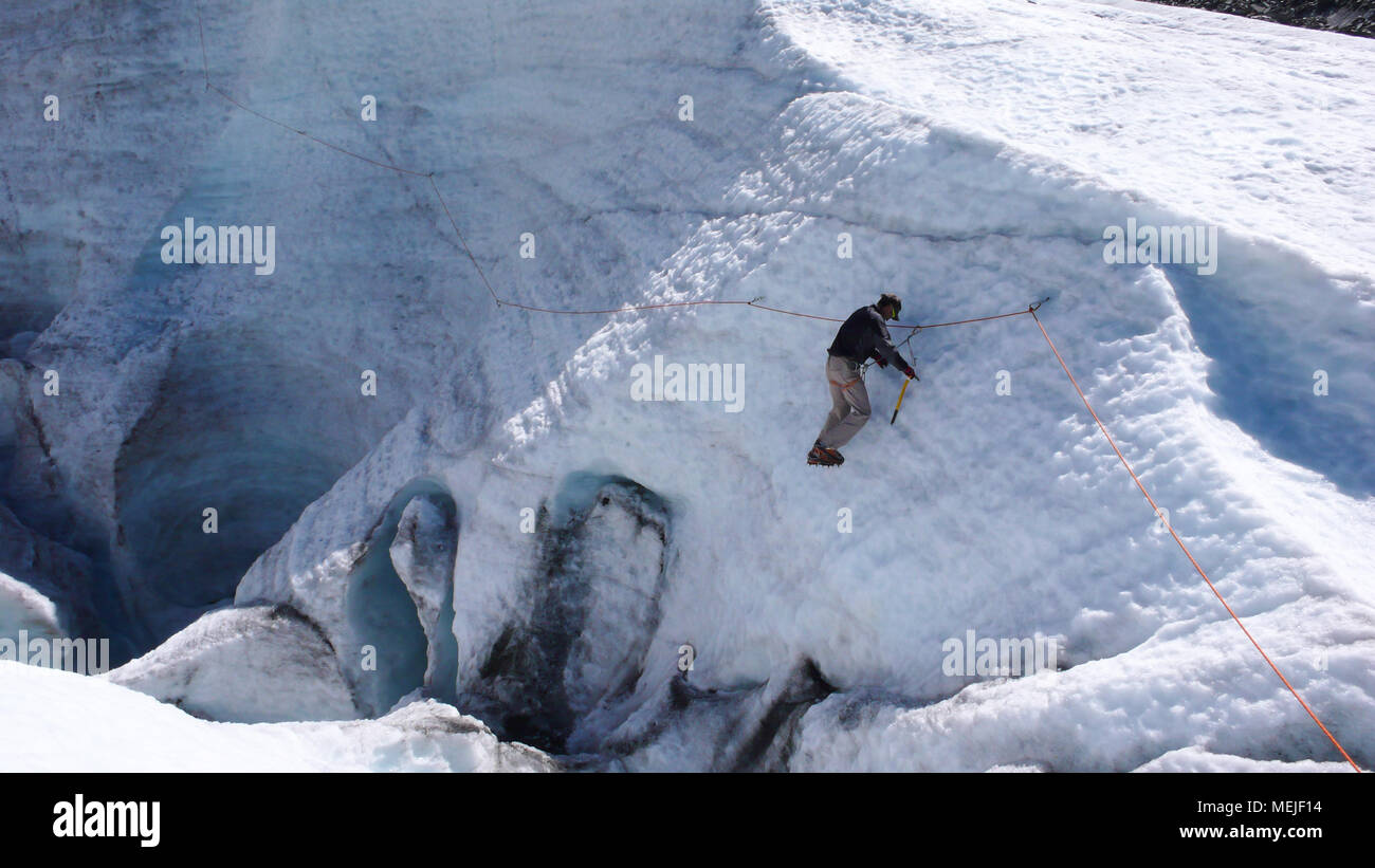 Guida di montagna formazione candidato piccozza e corda abilità su un ghiacciaio delle Alpi Svizzere Foto Stock