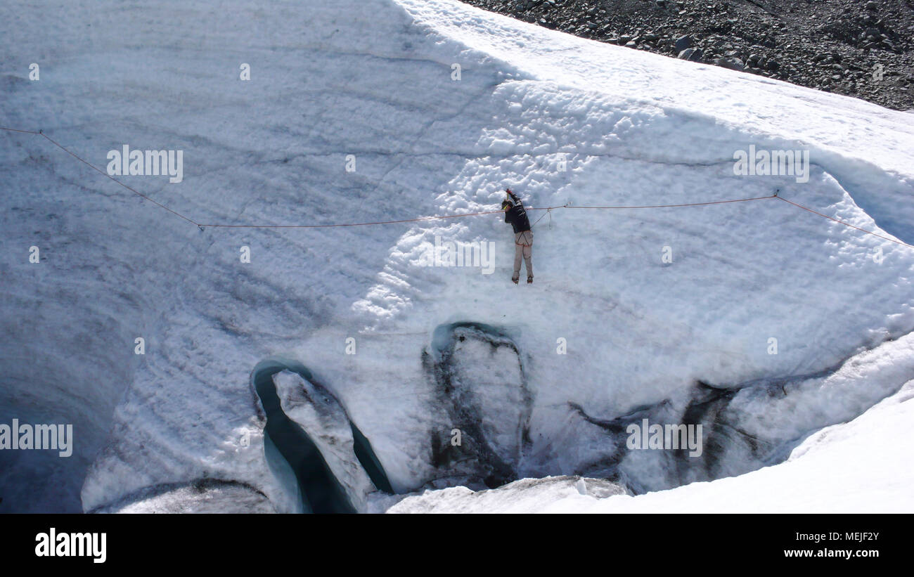 Guida di montagna formazione candidato piccozza e corda abilità su un ghiacciaio delle Alpi Svizzere Foto Stock