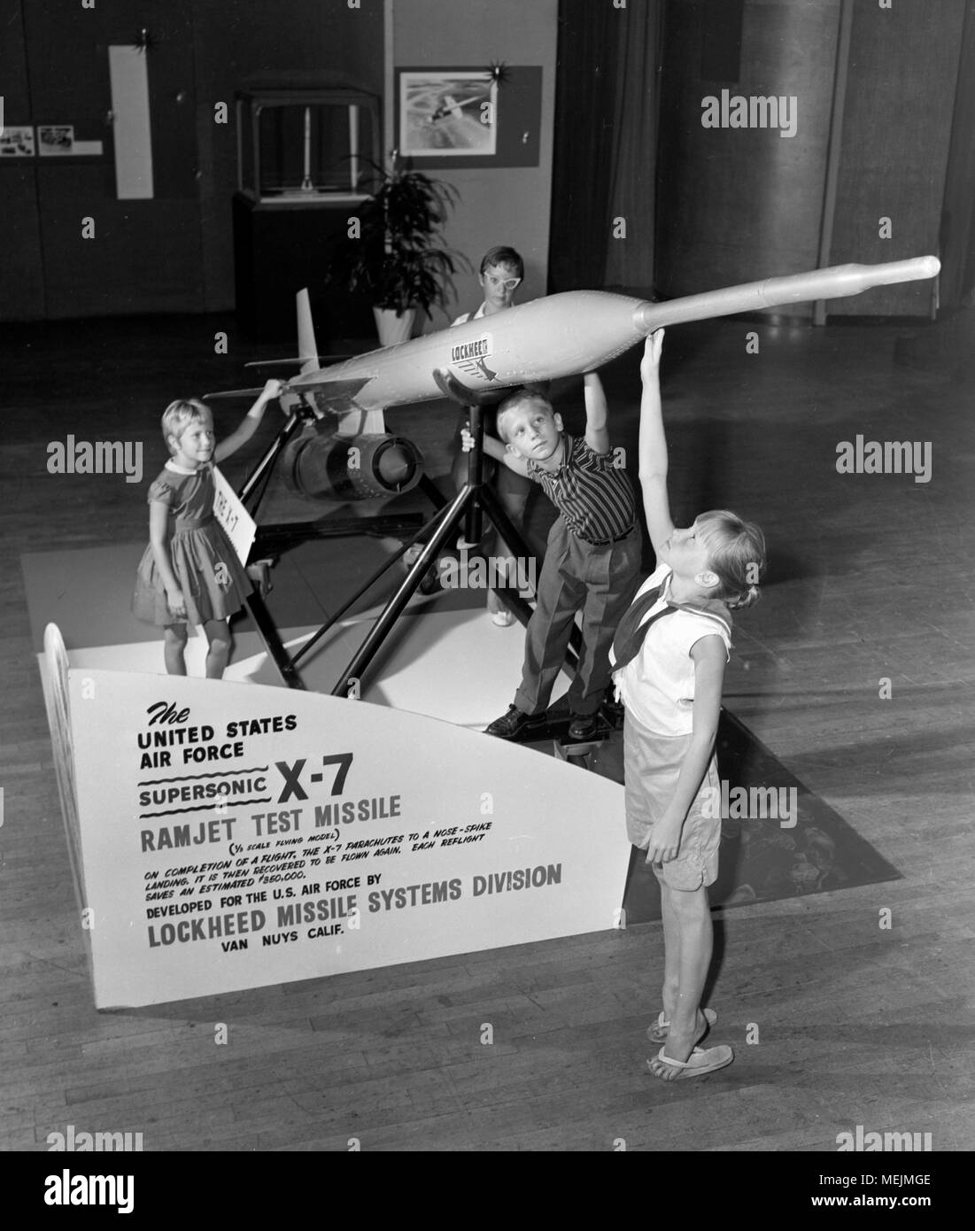 I bambini giocano su un modello di display di un Lockheed X-7 missile, ca. 1959. Foto Stock