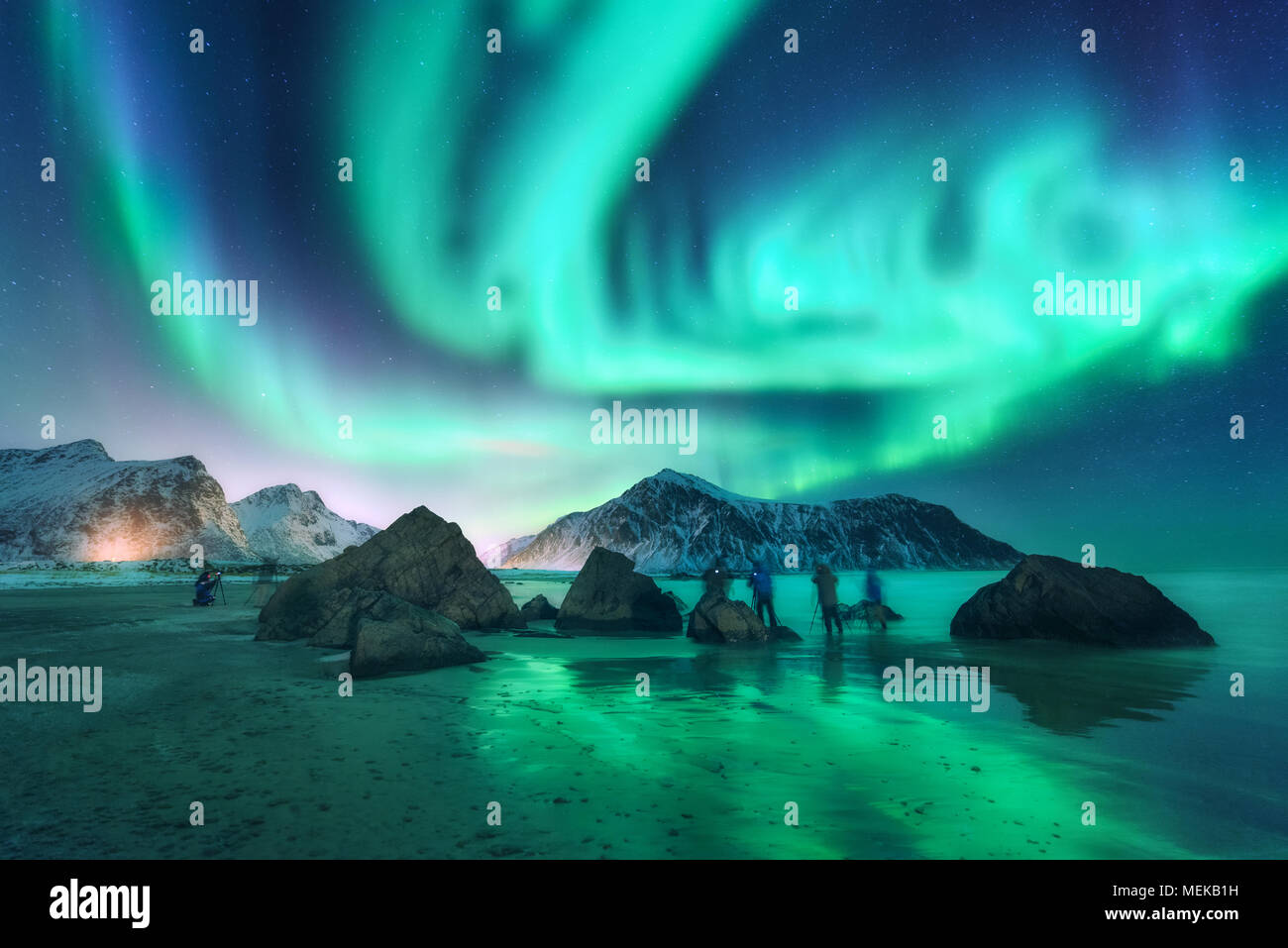 Green aurora boreale e fotografi. Aurora. Luci del nord in isole Lofoten in Norvegia. Cielo stellato con luci polari. Paesaggio notturno con aurora Foto Stock