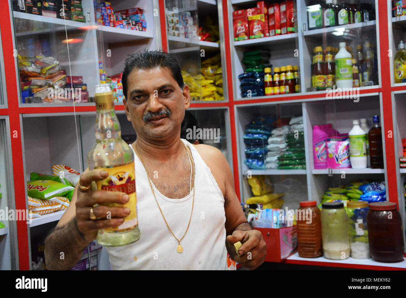 Pressione di stallo di mercato essendo titolare cordiale e offrendo un campione di una bevanda, Margao, India Foto Stock