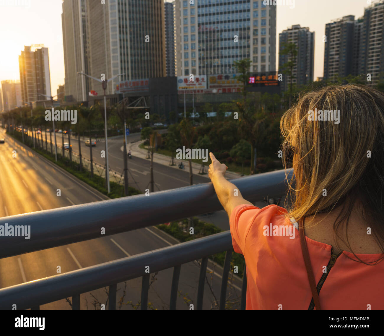 Il tramonto sulla città con modello femminile Foto Stock