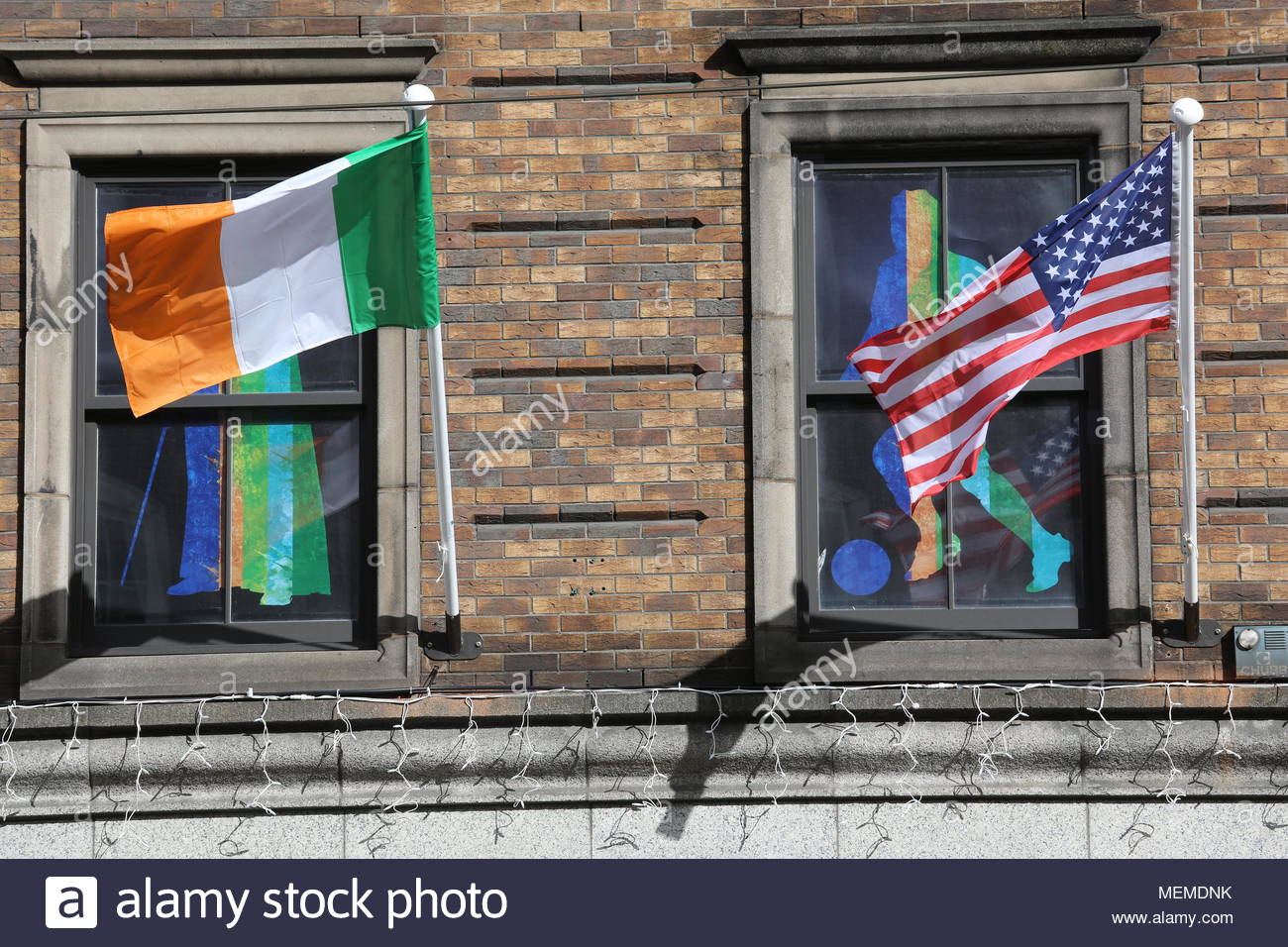 Due bandiere, il tricolore irlandese e le stelle e strisce appendere affiancati da windows in Dublino Foto Stock