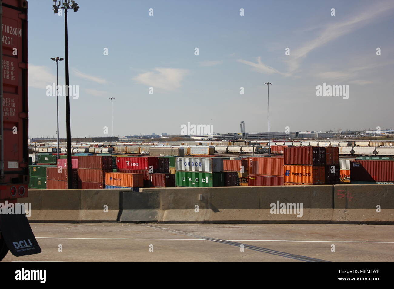 Vista di navigazione mercantile cantiere impianto di stoccaggio con una cassa di carico posto su un carrello a cavallo su un'autostrada. Foto Stock