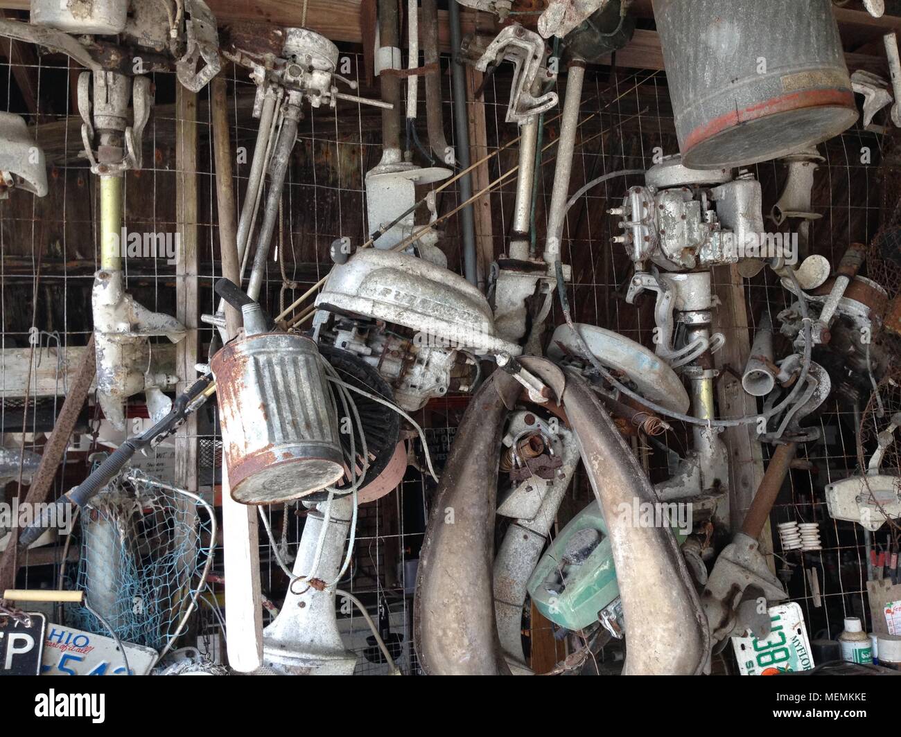Vecchio, vintage motori fuoribordo appesi al soffitto di un paese indietro accampamento di pesca in Florida Foto Stock