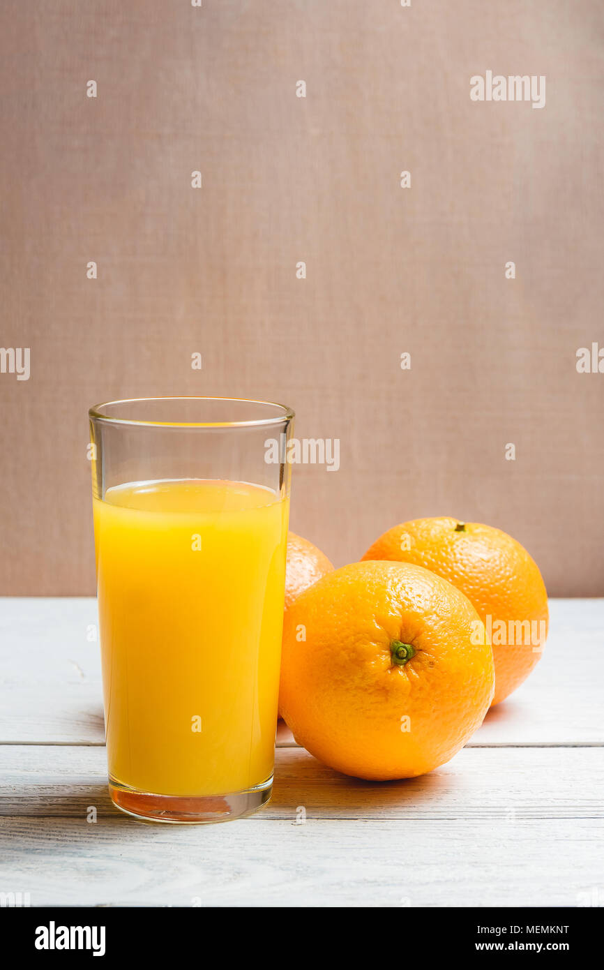 Fette di arancia e bere succo di frutta bianca su sfondo di legno. Un sano concetto con Copyspace Foto Stock