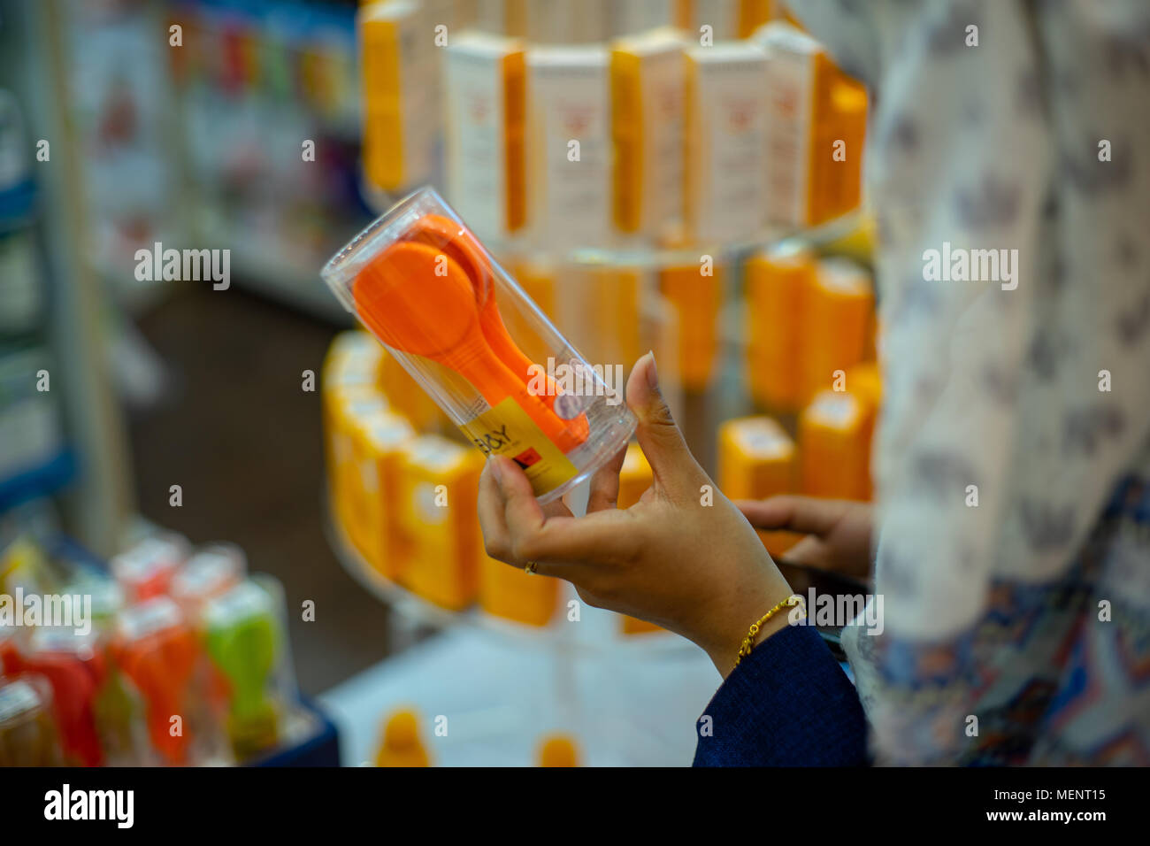 Una donna holding funky colore di capelli applicatore a medical store Foto Stock