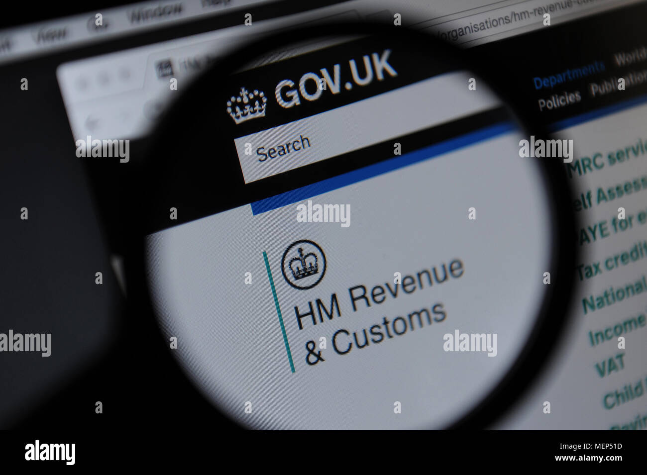 La HM Revenue e sito web doganali visto attraverso una lente di ingrandimento Foto Stock