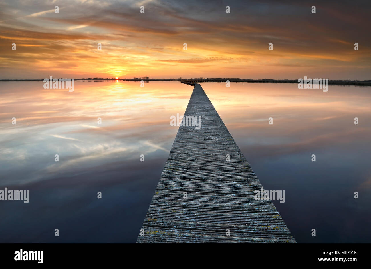 Lunga passerella sul lago grande a serene sunset Foto Stock